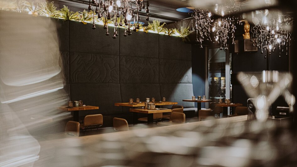 Elegantes Restaurantinterieur mit stilvollen Tischen und Kronleuchtern. | © Joel Kernasenko