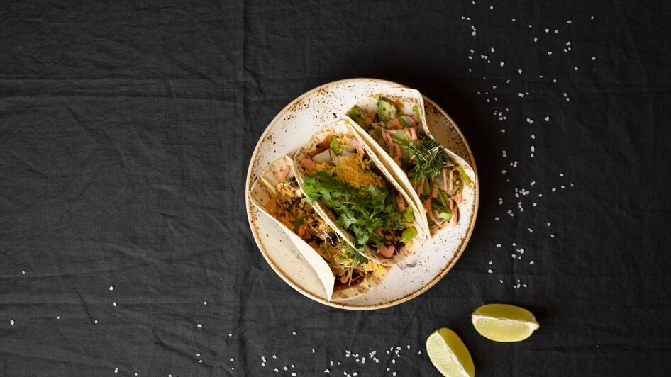 Drei leckere Tacos auf einem Teller, garniert mit frischen Zutaten und Limettenscheiben. | © Jauk Katharina