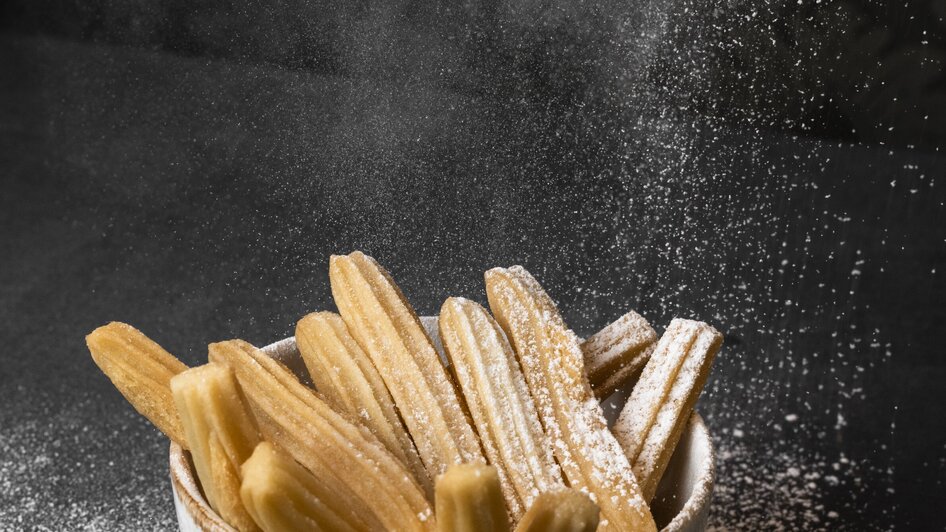 Eine Schüssel mit Churros, die mit Puderzucker bestäubt sind. | © Jauk Katharina