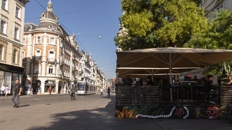 Straßenszene mit Café und Gebäuden in Graz. | © Jauk Katharina