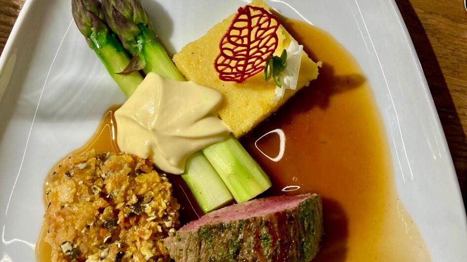 Ein köstlicher Teller mit Fleisch, Gemüse und Soße.