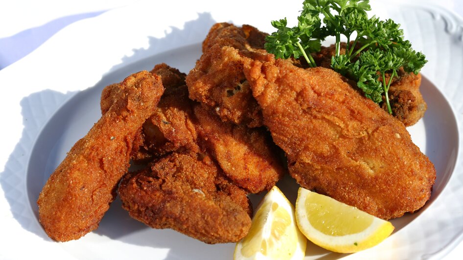 Leckere, knusprige frittierte Hühnchenstücke mit Zitronen und Petersilie.
