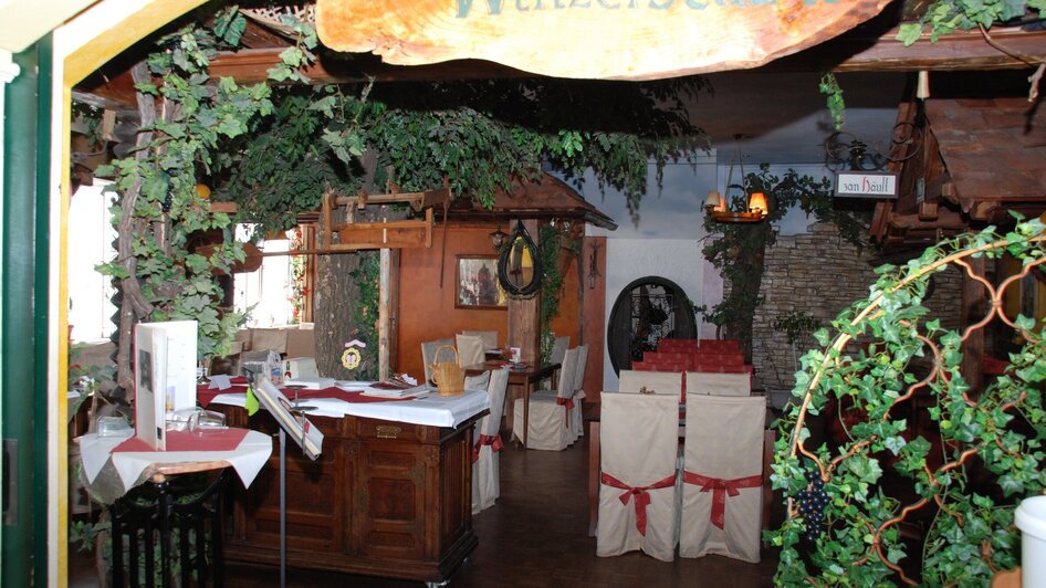 Gemütliches Restaurant mit weinartigem Dekor und gedeckten Tischen. | © Rudolf