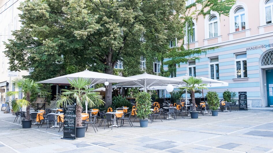Gemütliche Außenterrasse eines Restaurants in Graz mit Tischen und Stühlen. | © Schäffner