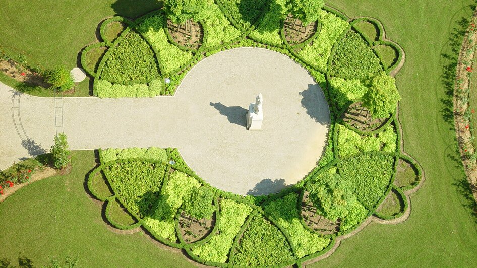Luftaufnahme des Schlossparks von Schloss Eggenberg in Graz mit runden Gartenanlagen.