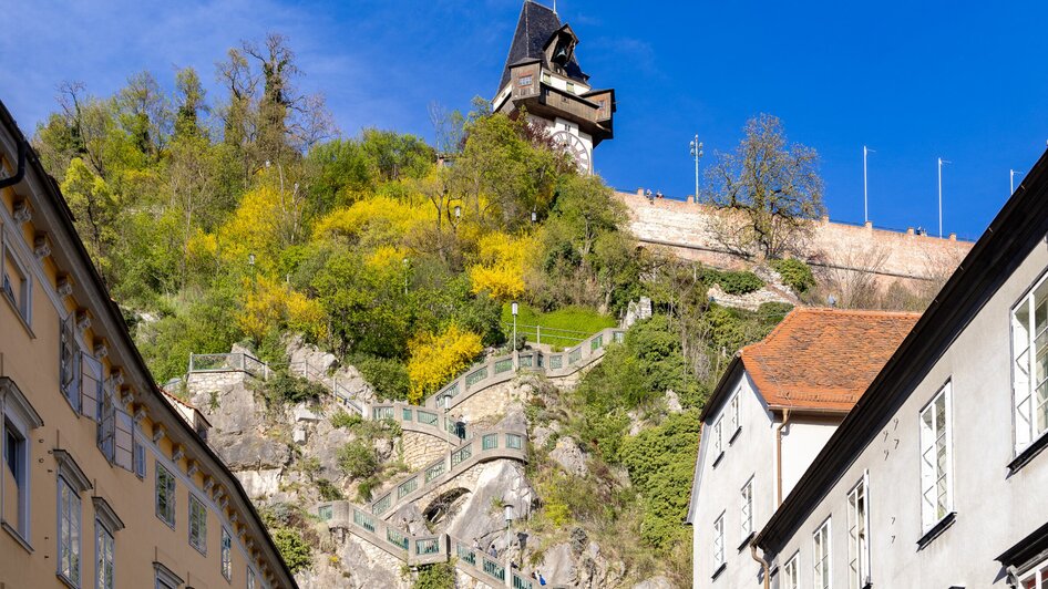 Der Grazer Uhrturm oberhalb der Stadt Graz mit dem Schlossbergsteig.