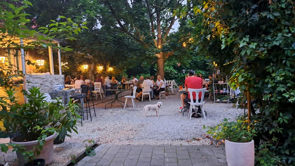 Gemütliches Abendessen im Freien mit Gästen und einem Hund. | © Galghoura