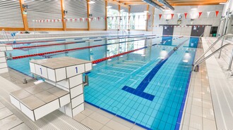 Innenansicht des Sport Union Hallenbads mit Wasser und Sprungbrettern. | © Harald Tauderer
