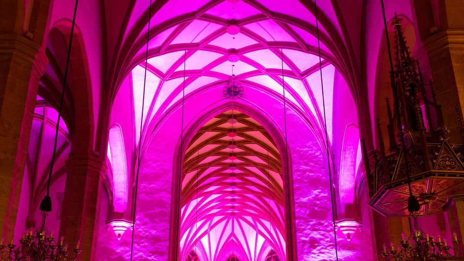 Innenansicht der Stadtpfarrkirche in Graz, beleuchtet in Pink.