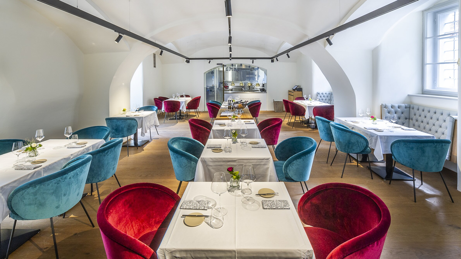 Elegantes Restaurant mit bunten Stühlen und gedeckten Tischen. | © Paul Stajan