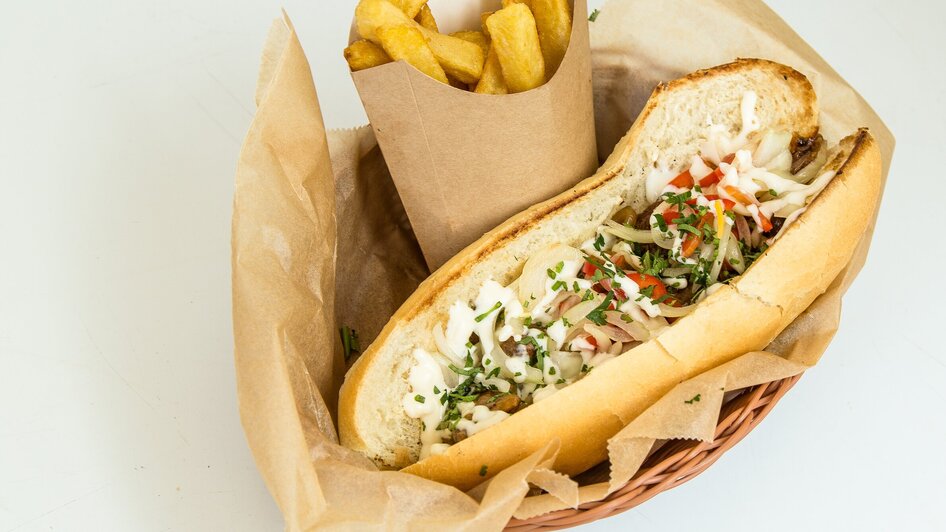 Sandwich gefüllt mit Salat mit Pommes in einem Körbchen.
