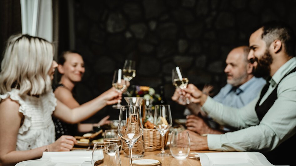 Freunde stoßen mit Gläsern an einem Tisch im Wirtshaus Thorbauer an. | © Julian Wallner