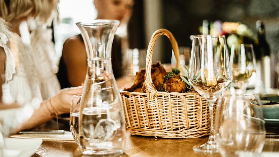 Schön Gedeckter Tisch mit Gläsern und einem Korb mit frischem Backhendl im Wirtshaus Thorbauer. | © Julian Wallner