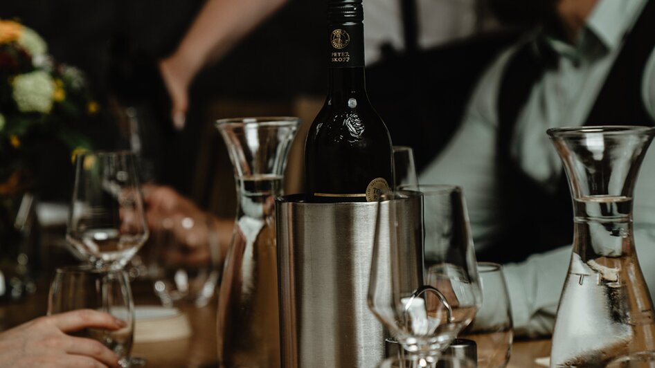 Gedeckter Tisch mit Gläsern und Weinflasche im Wirtshaus Thorbauer. | © Julian Wallner