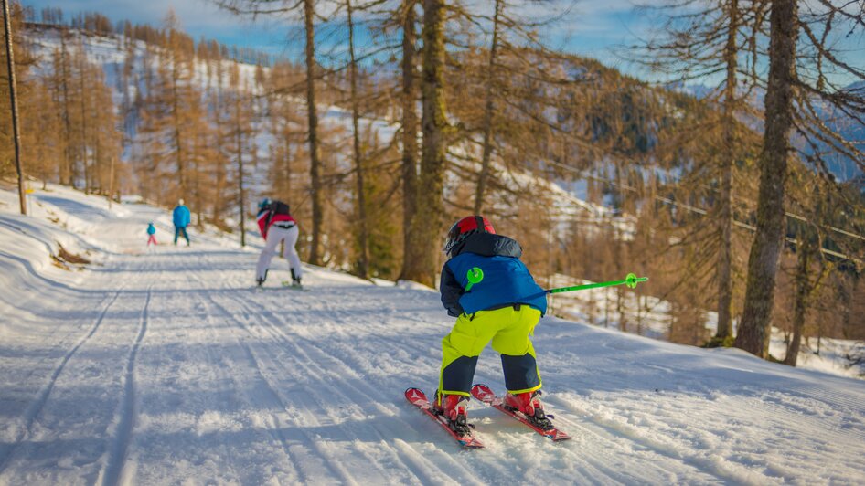 Familie am Skifahren auf dem Skiweg.